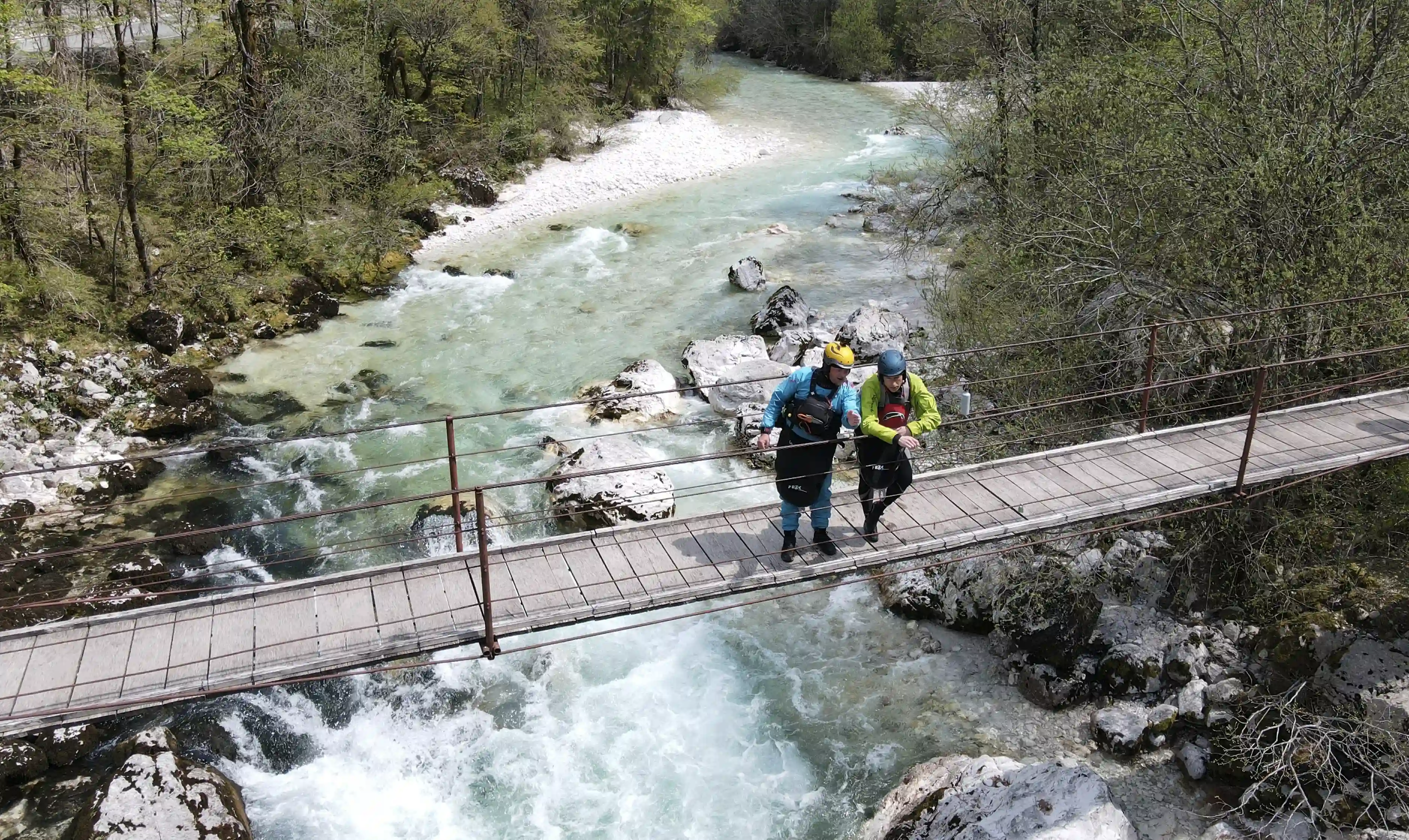 Kayakers standing on a bridge on the Soca